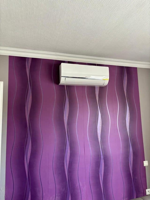 Unité intérieure de climatisation installée sur mur coloré à Bebing